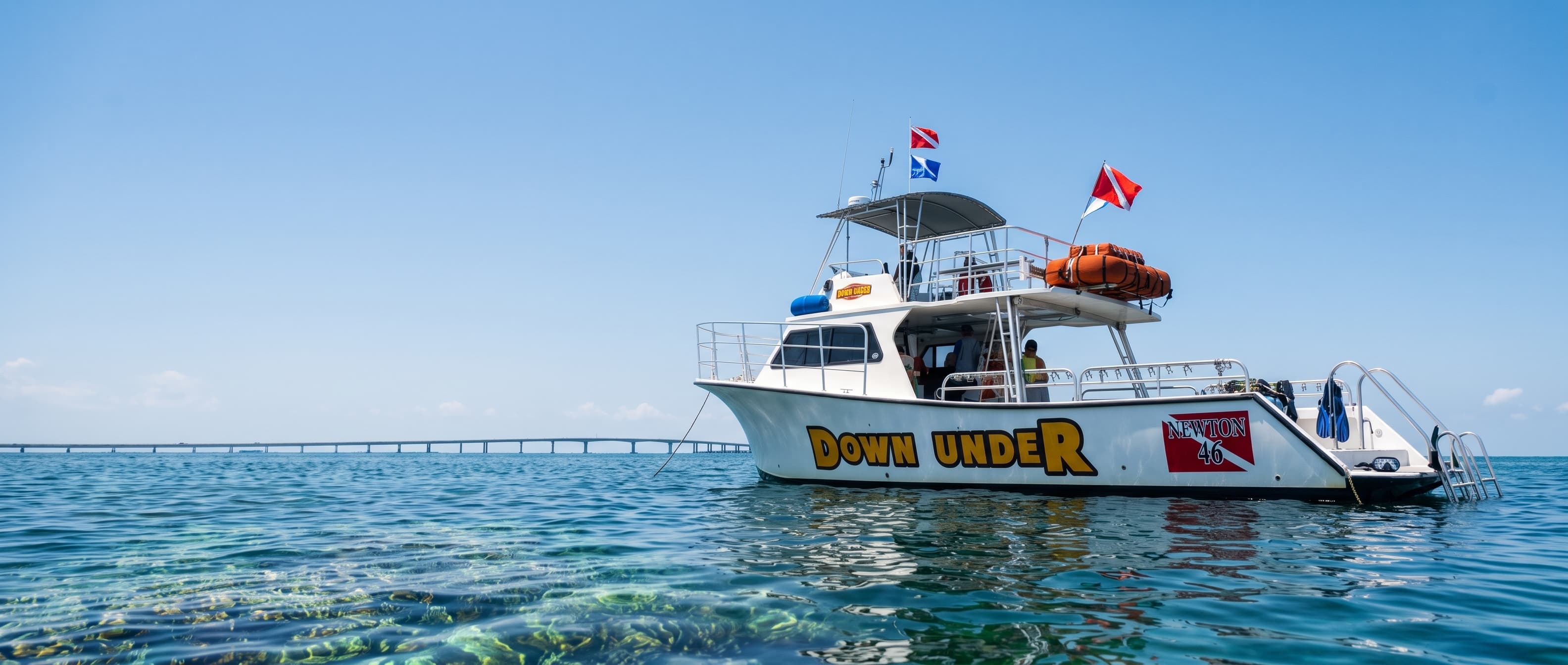 The Down Under dive boat anchored on vibrant turquoise water